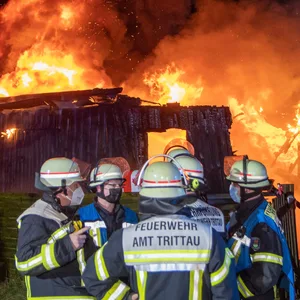 Feuerwehrkräfte vor dem brennenden Ferienhaus in Trittau.