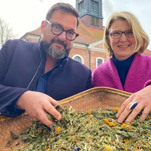 Reerdigung: Auf Heu und auf Stroh: Der Friedhofsbeauftragte des Kirchenkreises Lübeck-Lauenburg Bernd K. Jacob stellt Pröpstin Frauke Eiben Substrat aus getrockneter Blumenwiese, Klee, Heu und Stroh vor, das bei einer Reerdigung verwendet werden kann. Foto: Bastian Modrow