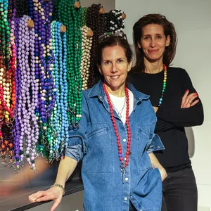 Michal Hirsch und Sophie Mahlo stehen vor bunten Holzperlenketten.