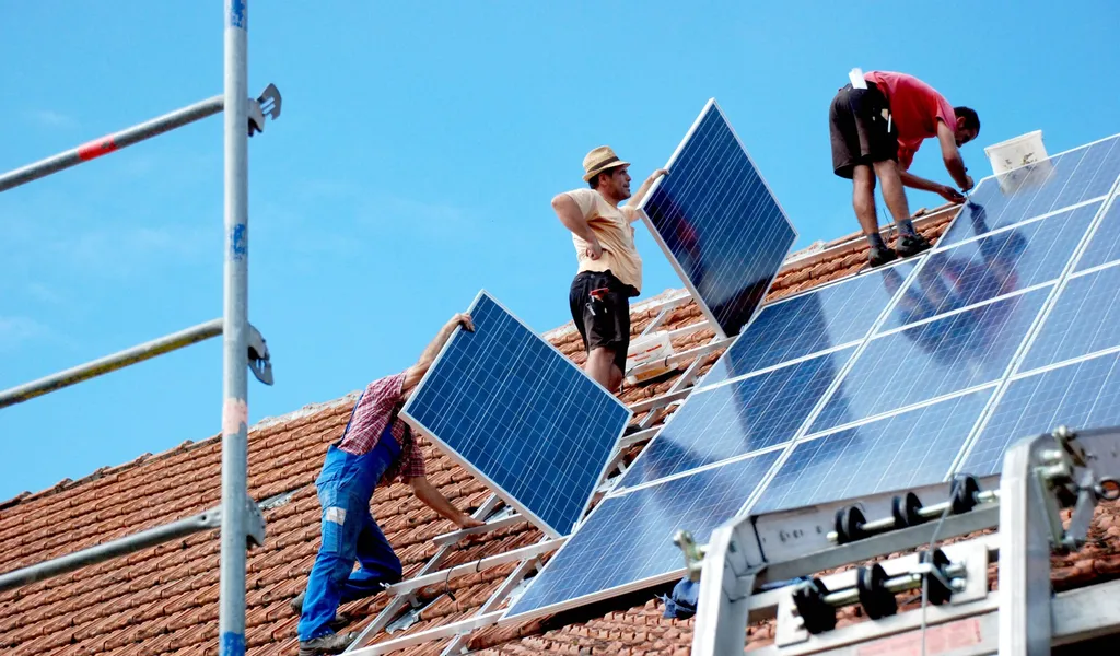 Handwerker montieren eine Solaranlage: In Hamburg besteht großer Bedarf an Fachkräften für Klimaberufe. (Symbolbild)