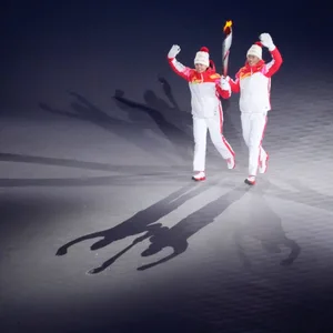 Dinigeer Yilamujiang und Zhao Jiawen (v.l.) entzündeten das olympische Feuer in Peking.