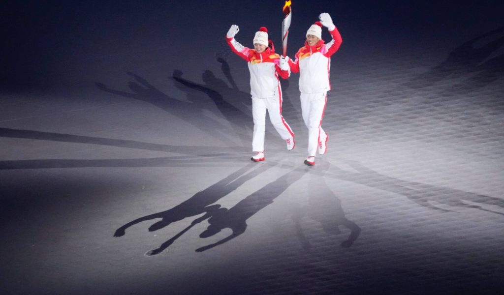 Dinigeer Yilamujiang und Zhao Jiawen (v.l.) entzündeten das olympische Feuer in Peking.