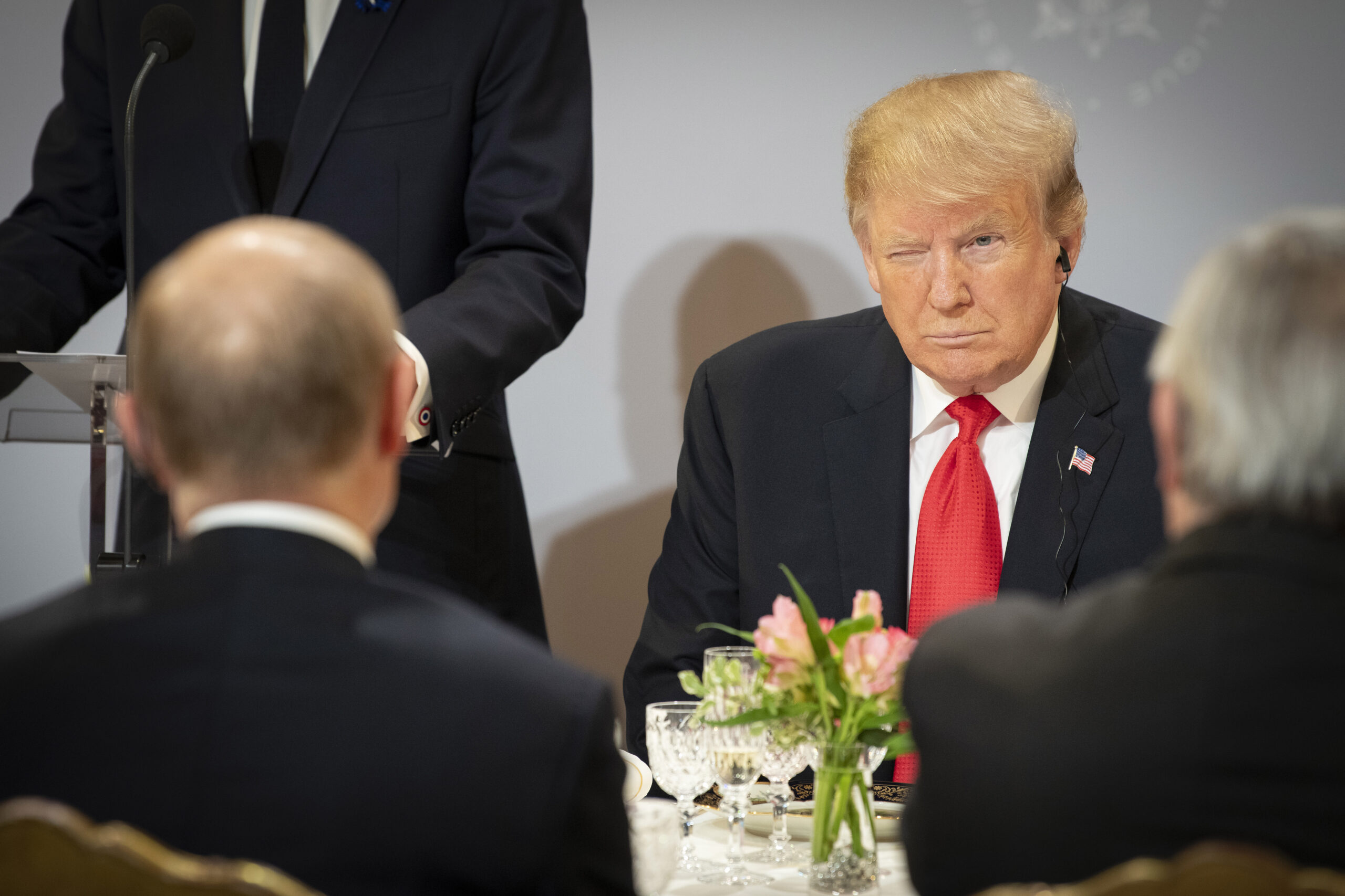 November 2018 in Paris: Donald Trump (M.) zwinkert Wladimir Putin (l.), während des Mittagessens im Elysee-Palast zu.