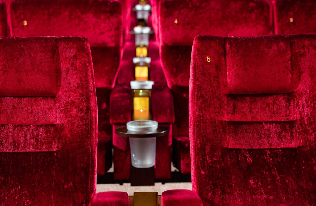 Rote Kinosessel aus Samt in einem leeren Saal.