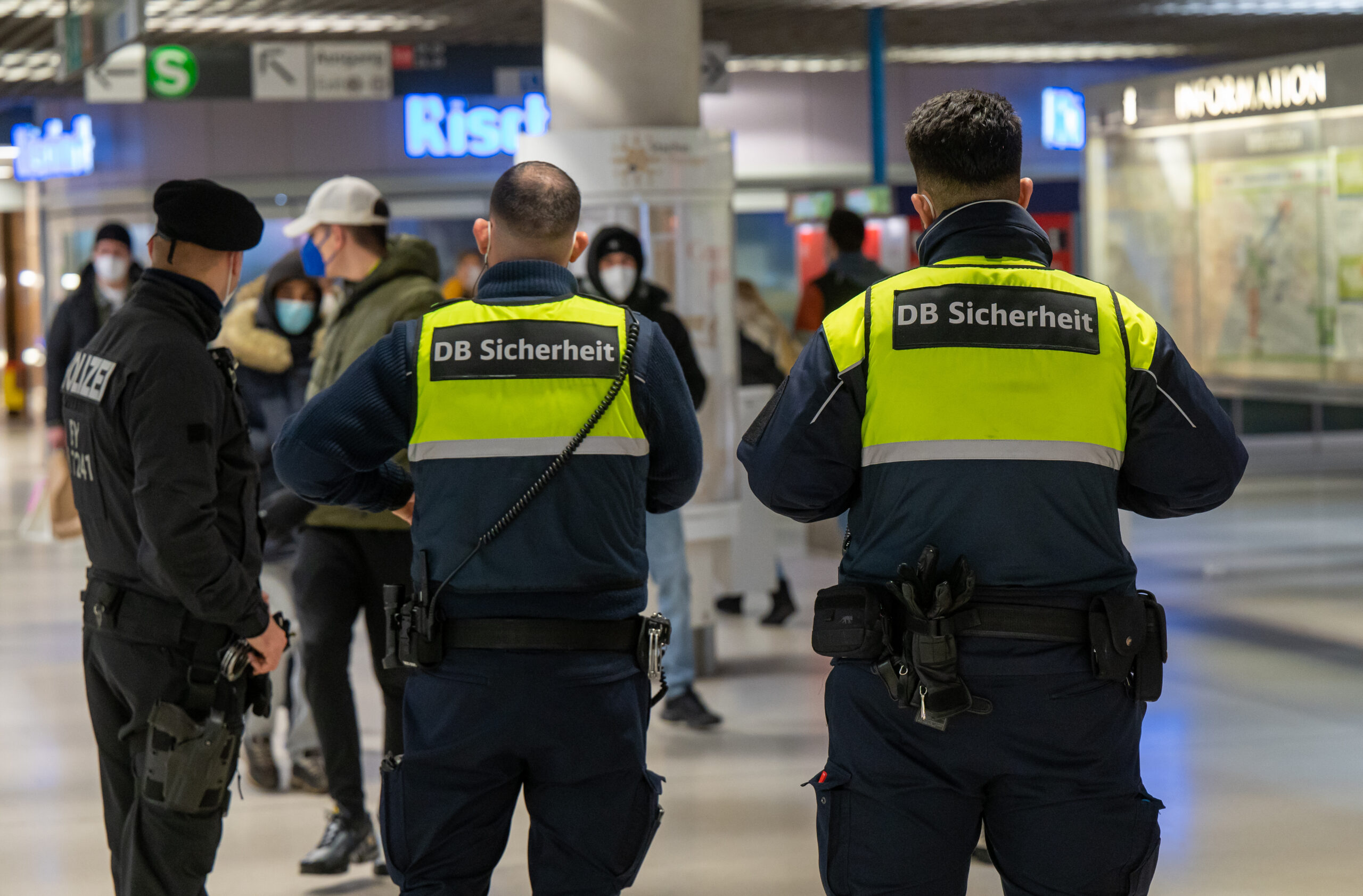 Sicherheitskräfte der Deutschen Bahn mit Polizist am Bahnhof.