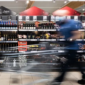 Symbolbild: Ein Mann geht mit seinem Einkaufswagen in einer Lidl-Filiale an Regalen vorbei