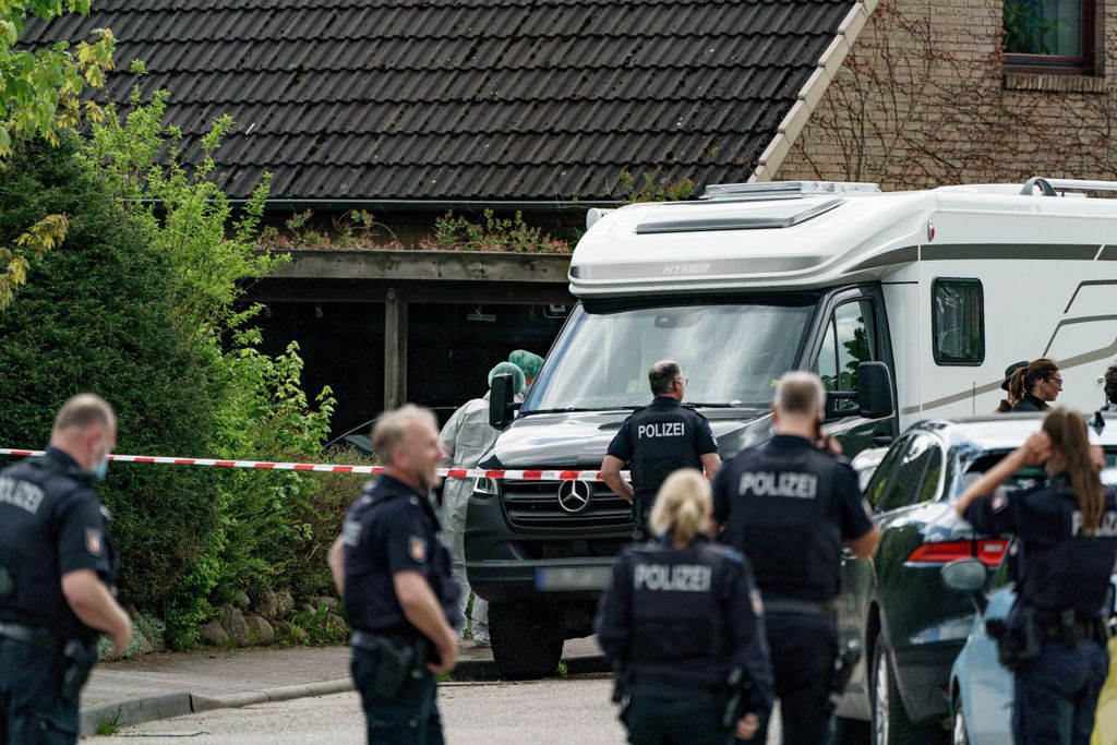 Un oficial de policía en la escena del crimen en Dänischenhagen, cerca de Kiel, se para frente a un divisor.
