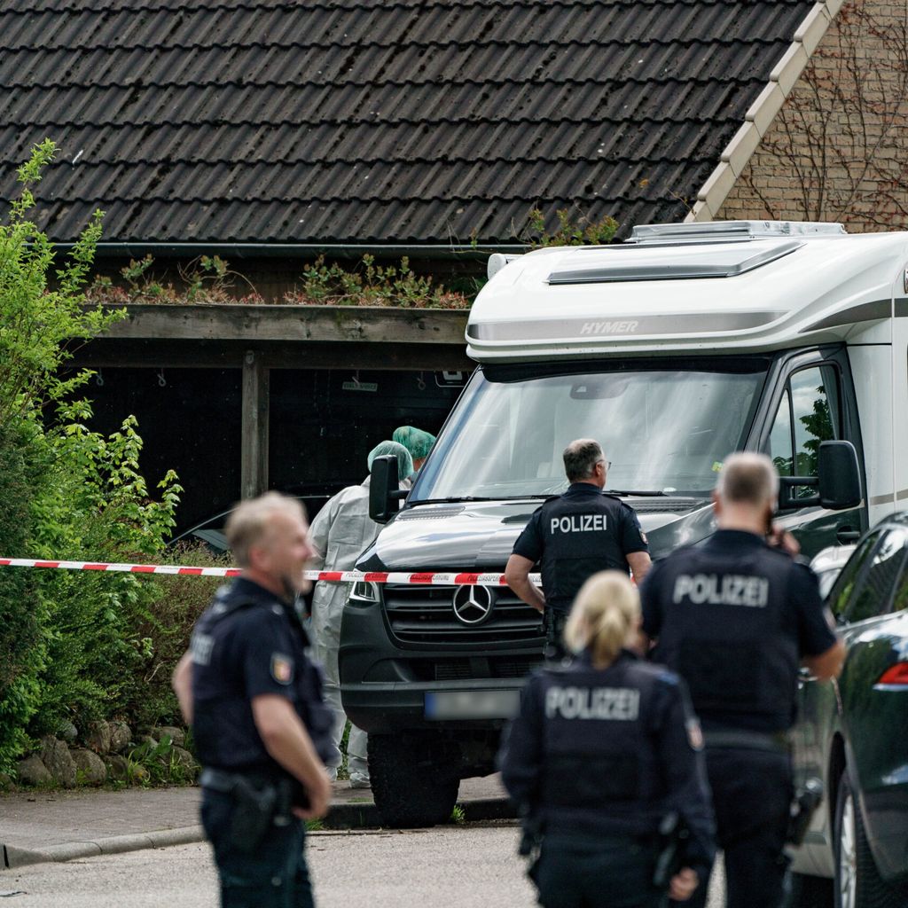 Polizisten vor Absperrband am Tatort in Dänischenhagen bei Kiel.