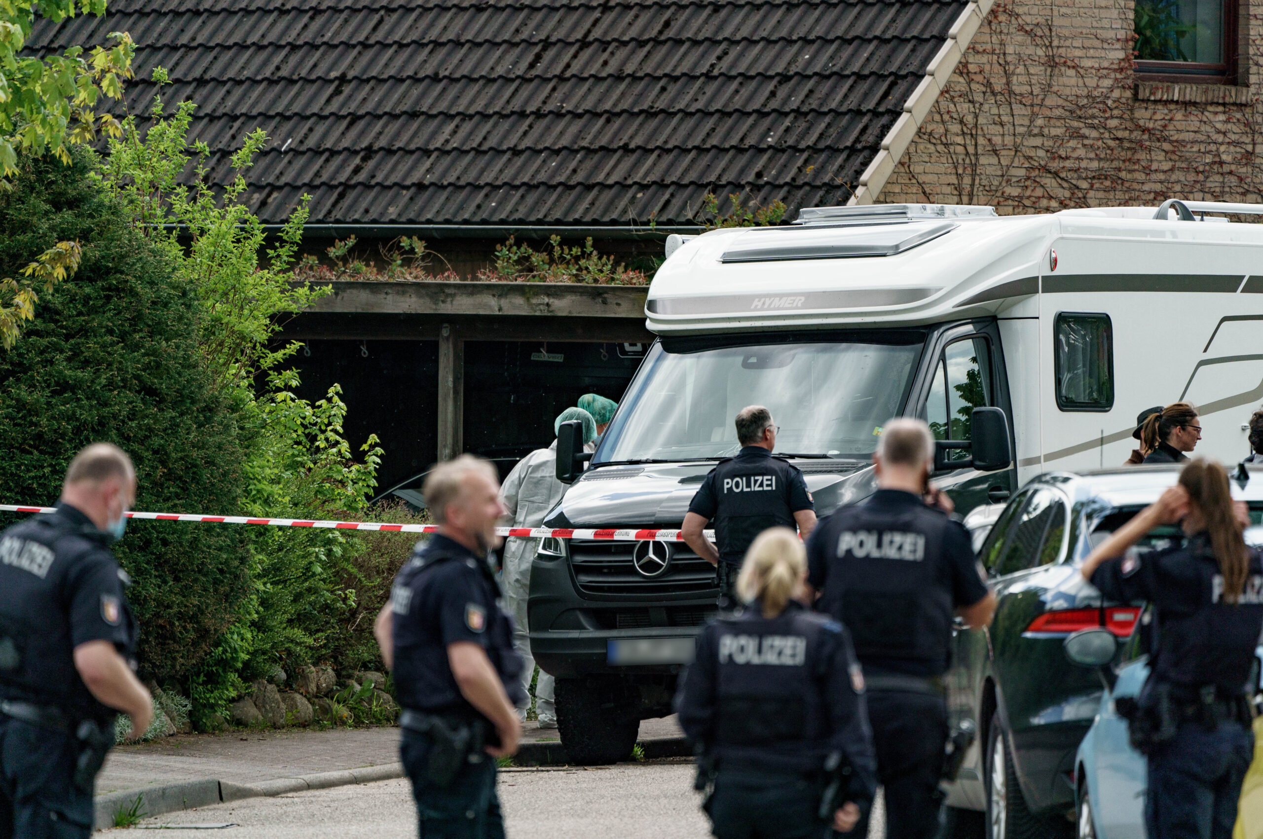 Tatort Dänischenhagen bei Kiel. Polizisten vor Absperrband vor einem Haus.