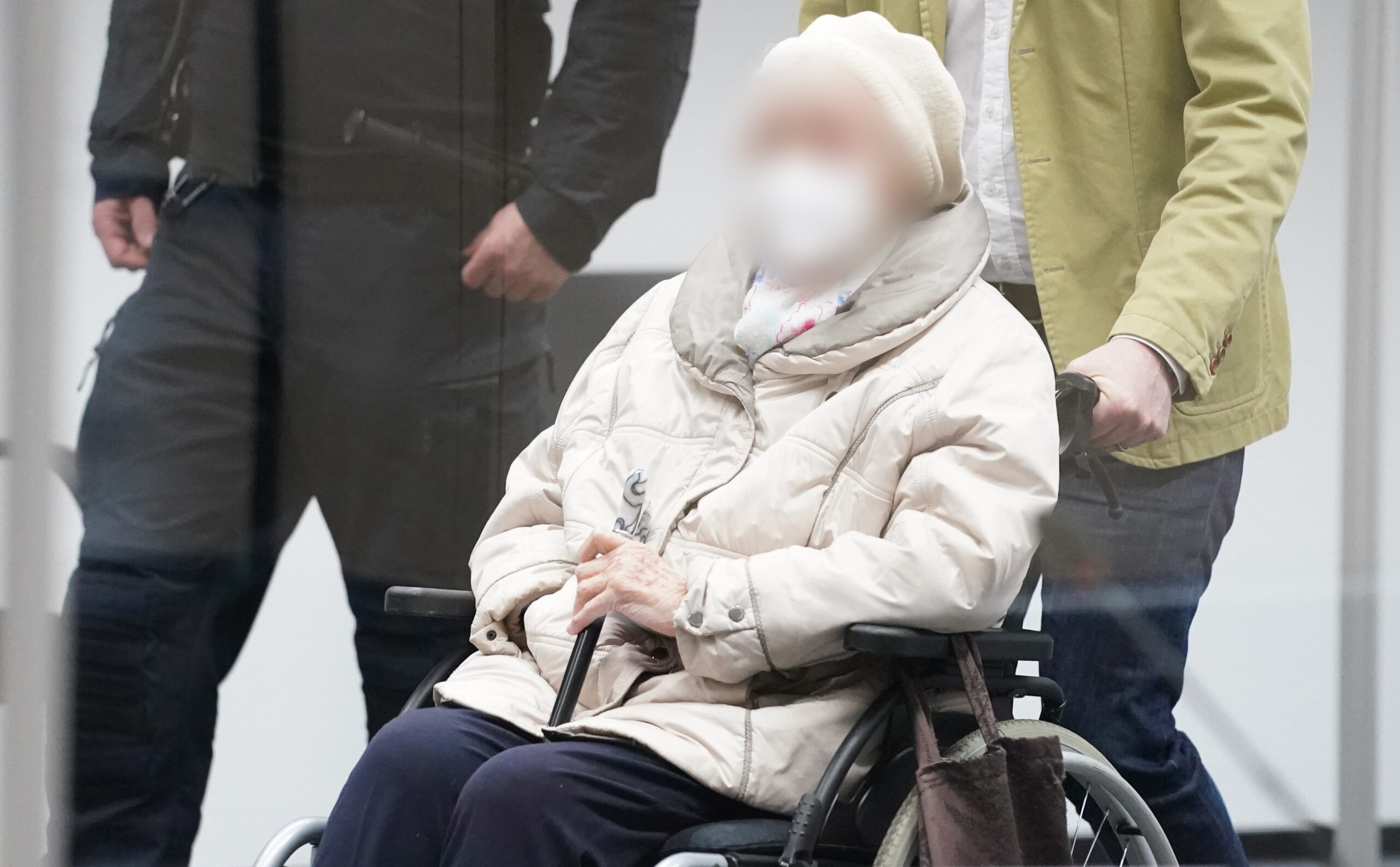 Die angeklagte Irmgard F. wird in einem Rollstuhl in den Gerichtssaal geschoben.