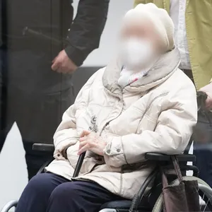 Die angeklagte Irmgard F. wird in einem Rollstuhl in den Gerichtssaal geschoben.