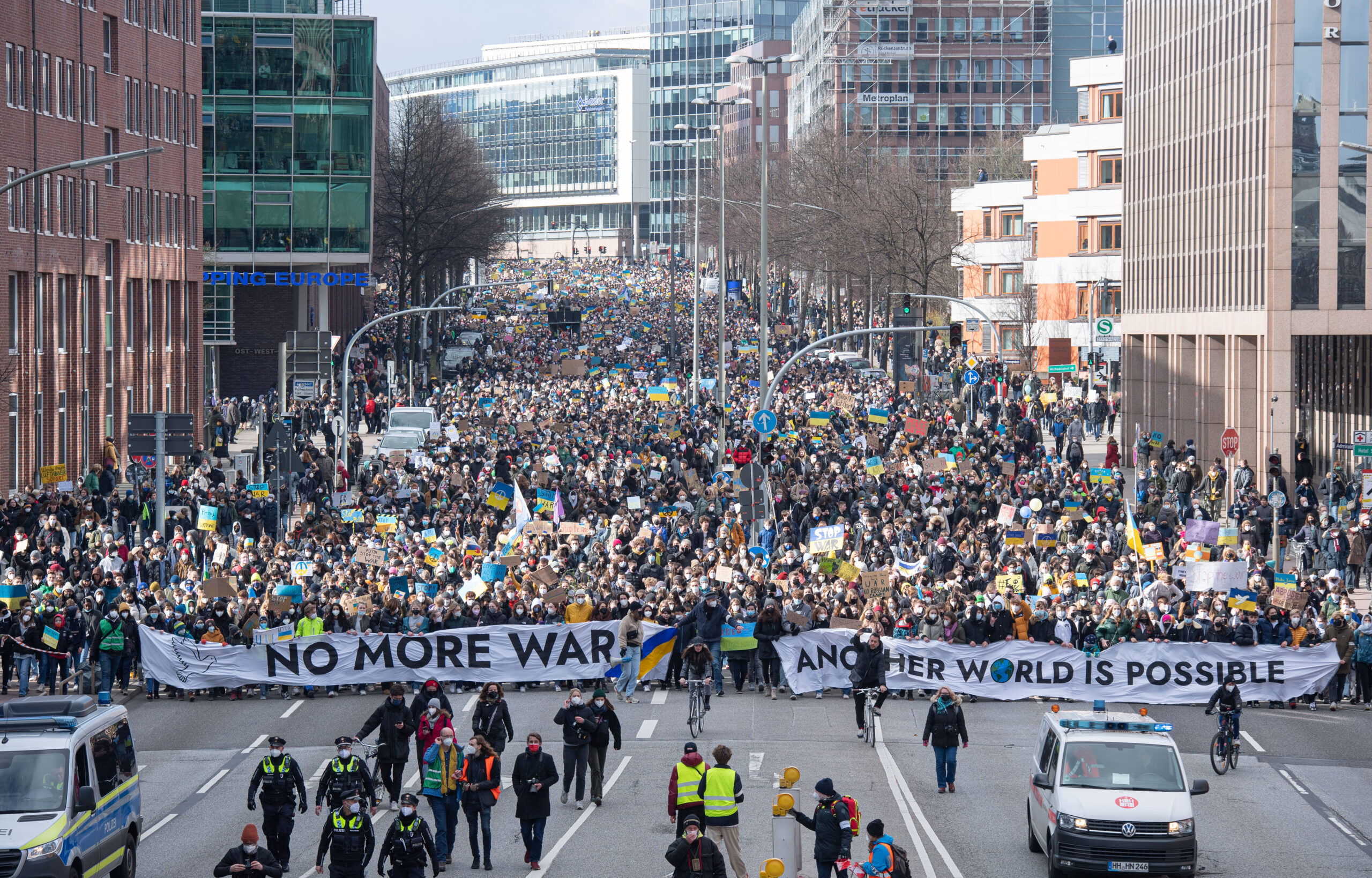 Viele tausend Demonstrierende gehen über die Willy-Brandt-Straße, eine Hauptverkehrsstraße Hamburgs, dabei tragen sie Transparente mit der Aufschrift „"No more war".