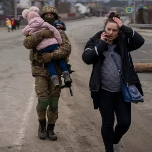 Ukrainische Soldaten tragen Babys und helfen einer fliehenden Familie in Irpin.