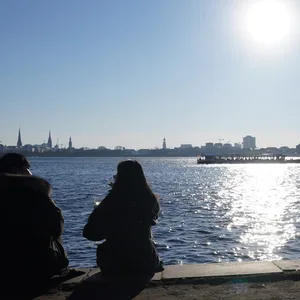 Passanten genießen die Sonne an der Außenalster. Das lässt sich an diesem Wochenende gut wiederholen.