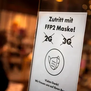 Ein Schild an einem Restaurant informiert über die FFP-2 Maskenpflicht.