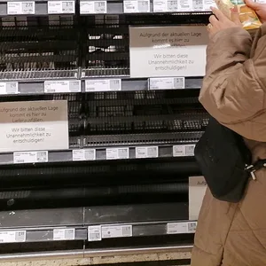 Kunden stehen in Supermärkten vor leeren Regalen