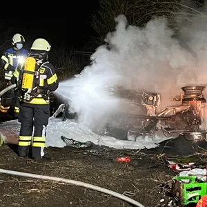 Feuerwehrkräfte löschen den brennenden Radlader.