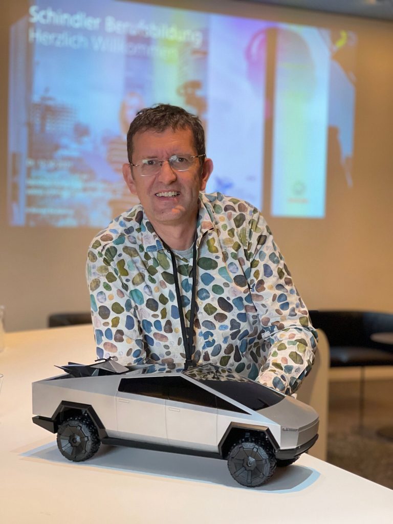 Louis Palmer steht neben dem Modell eines Elektro-Autos