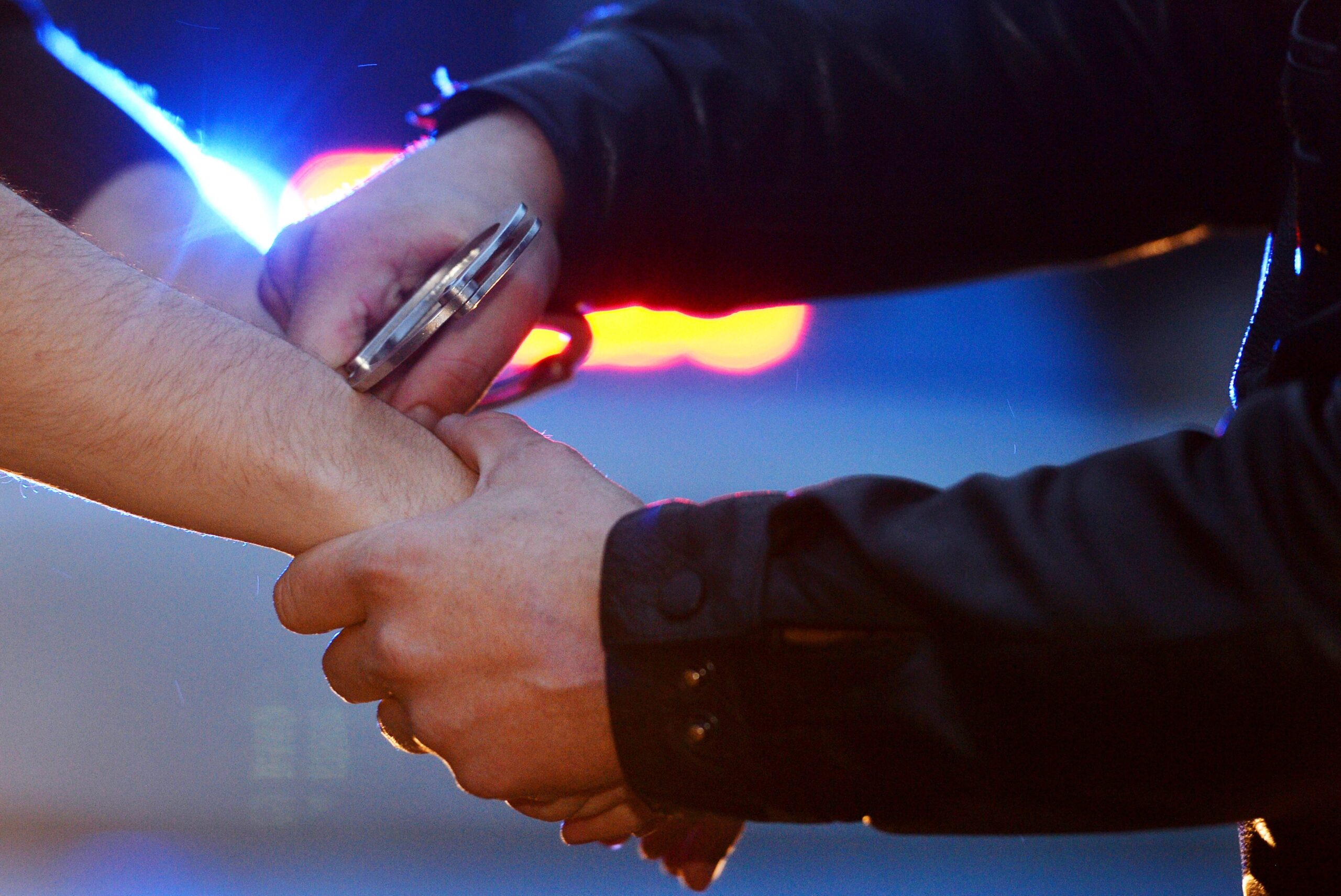 Ein Polizist nimmt einen Mann fest (Symbolbild).