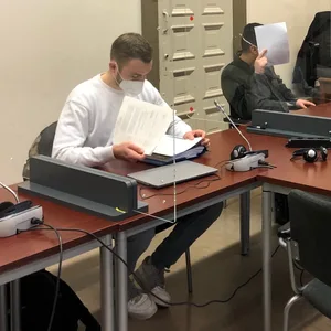 Der Angeklagte versteckt sein Gesicht vor den Kameras.