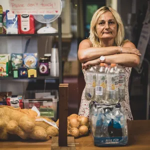 Andrea De Luna stützt sich auf eine Palette Wasserflasche. Sie versorgt seit zwei Jahren Bedürftige mit Essen.