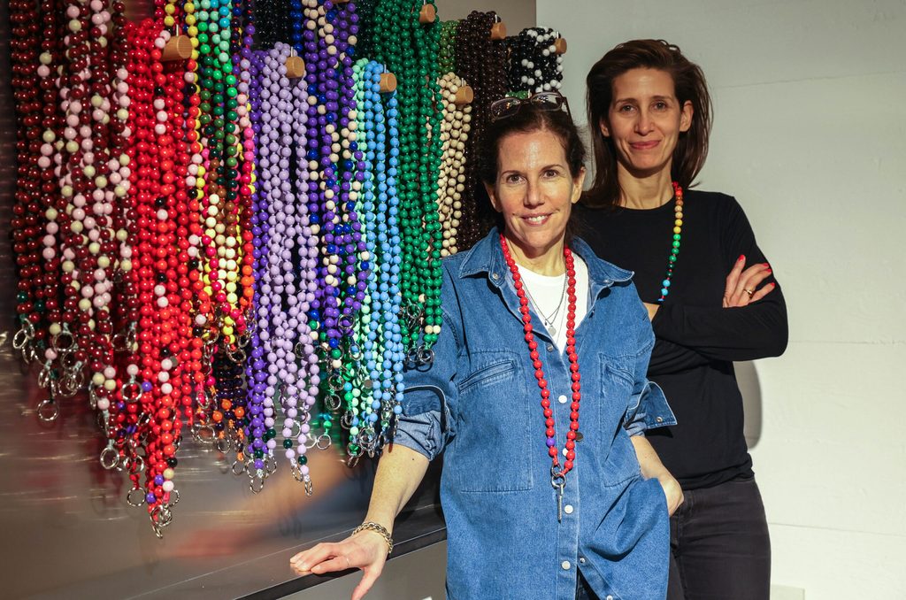 Michal Hirsch und Sophie Mahlo stehen vor den bunten Handyketten.