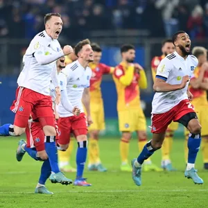 Grenzenloser Jubel: Sebastian Schonlau, Moritz Heyer und Josha Vagnoman stürmen nach dem letzten Karlsruher Elfmeter Richtung Heuer Fernandes.
