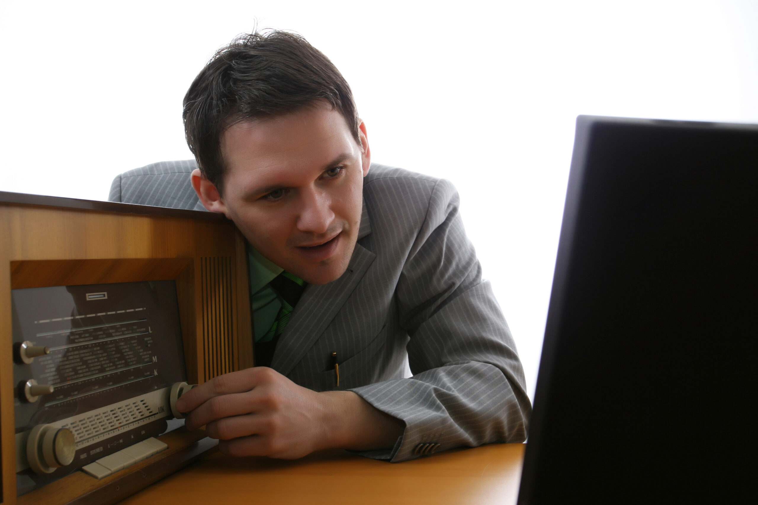Symbolbild: Ein Mann sucht an einem alten Radio nach einem Programm.
