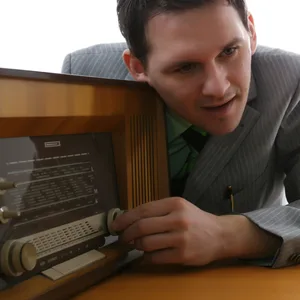 Symbolbild: Ein Mann sucht an einem alten Radio nach einem Programm.
