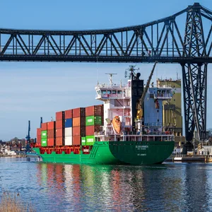 Ein Containerschiff passiert die Rendsburger Hochbrücke. Nach sechs Jahren fährt auch die Schwebefähre dort wieder