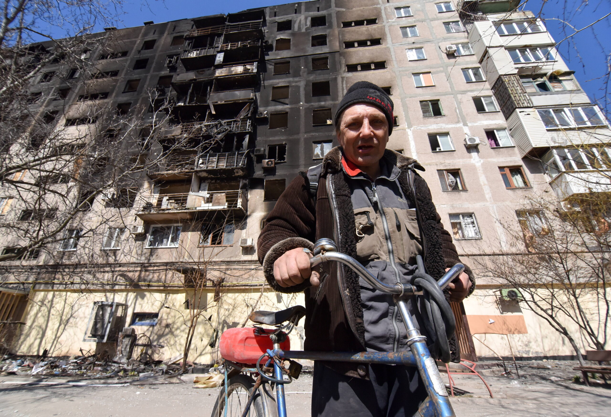 Ein Bewohner Mariupols steht vor der Ruine eines von Russen bombardierten Hochhauses.