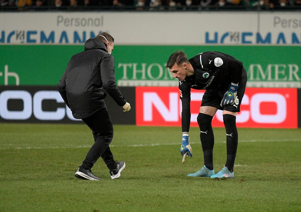 Fürths Keeper Andreas Linde sucht mit einem Betreuer nach dem verlorenen Zahn.