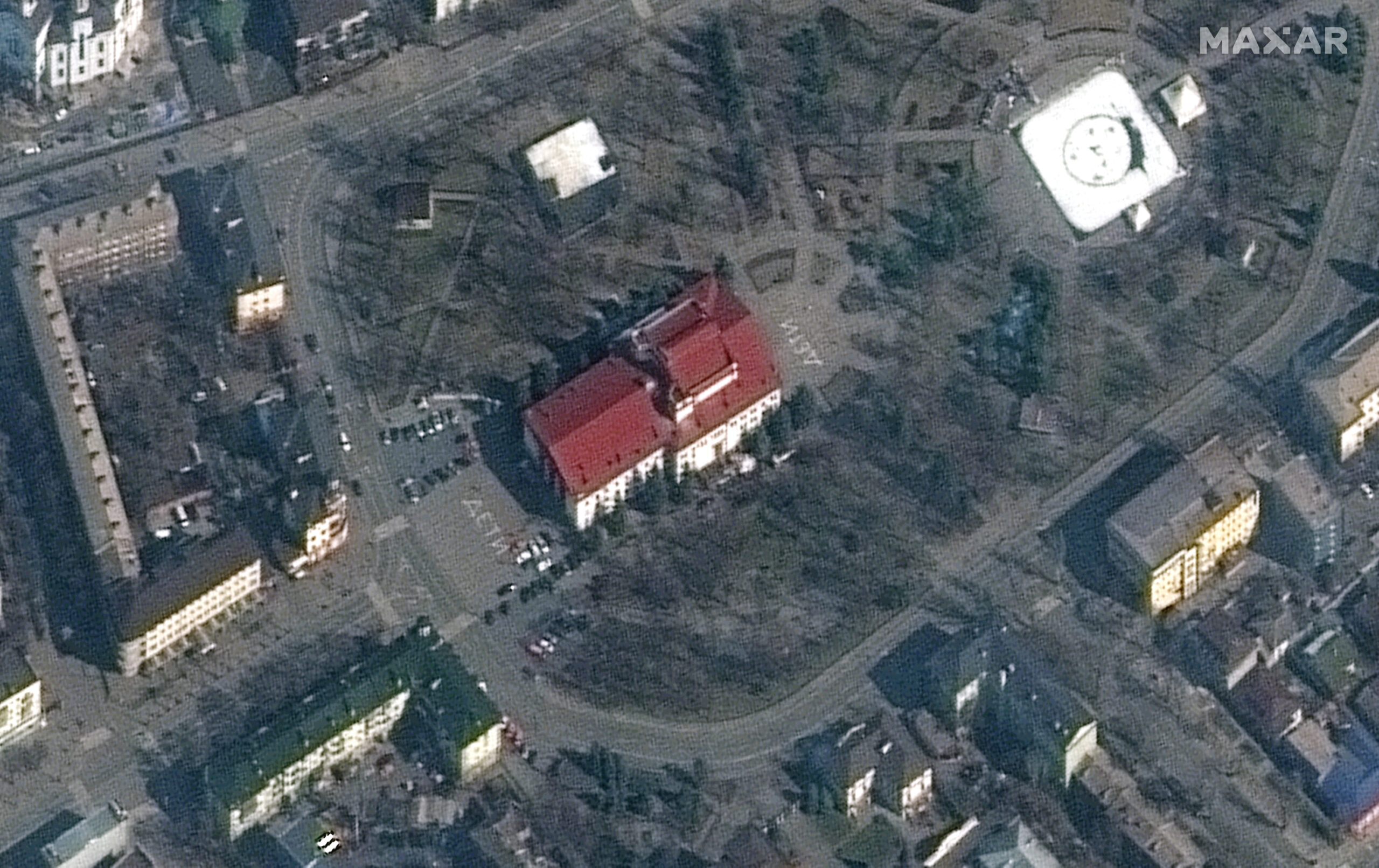 Dieses von Maxar Technologies zur Verfügung gestellte Satellitenbild zeigt das Theater in Mariupol. Vor und hinter dem Gebäude sind Schriftzüge zu sehen.