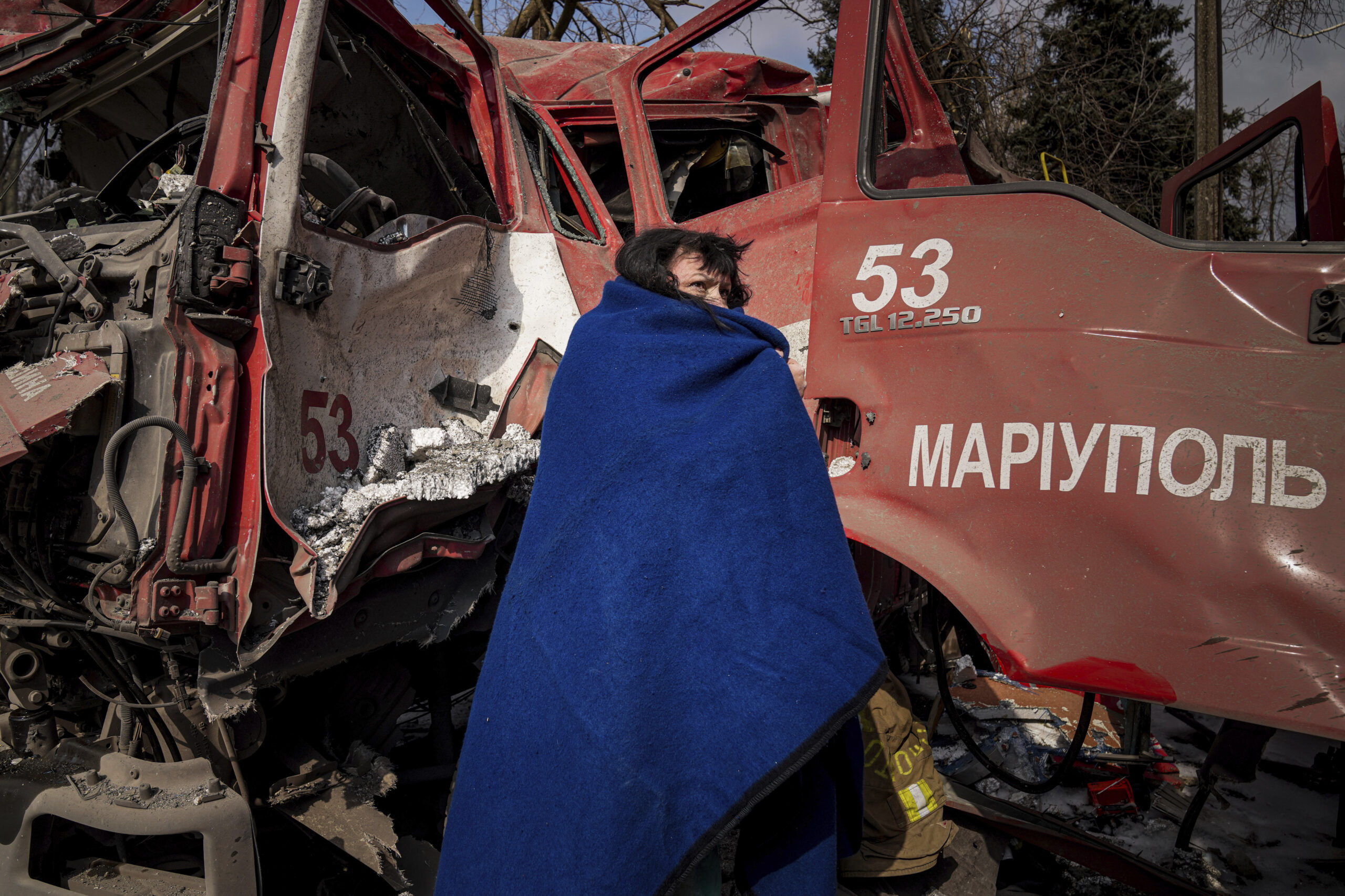 Eine Frau bedeckt sich in Mariupol mit einer Decke nach einem Beschuss.