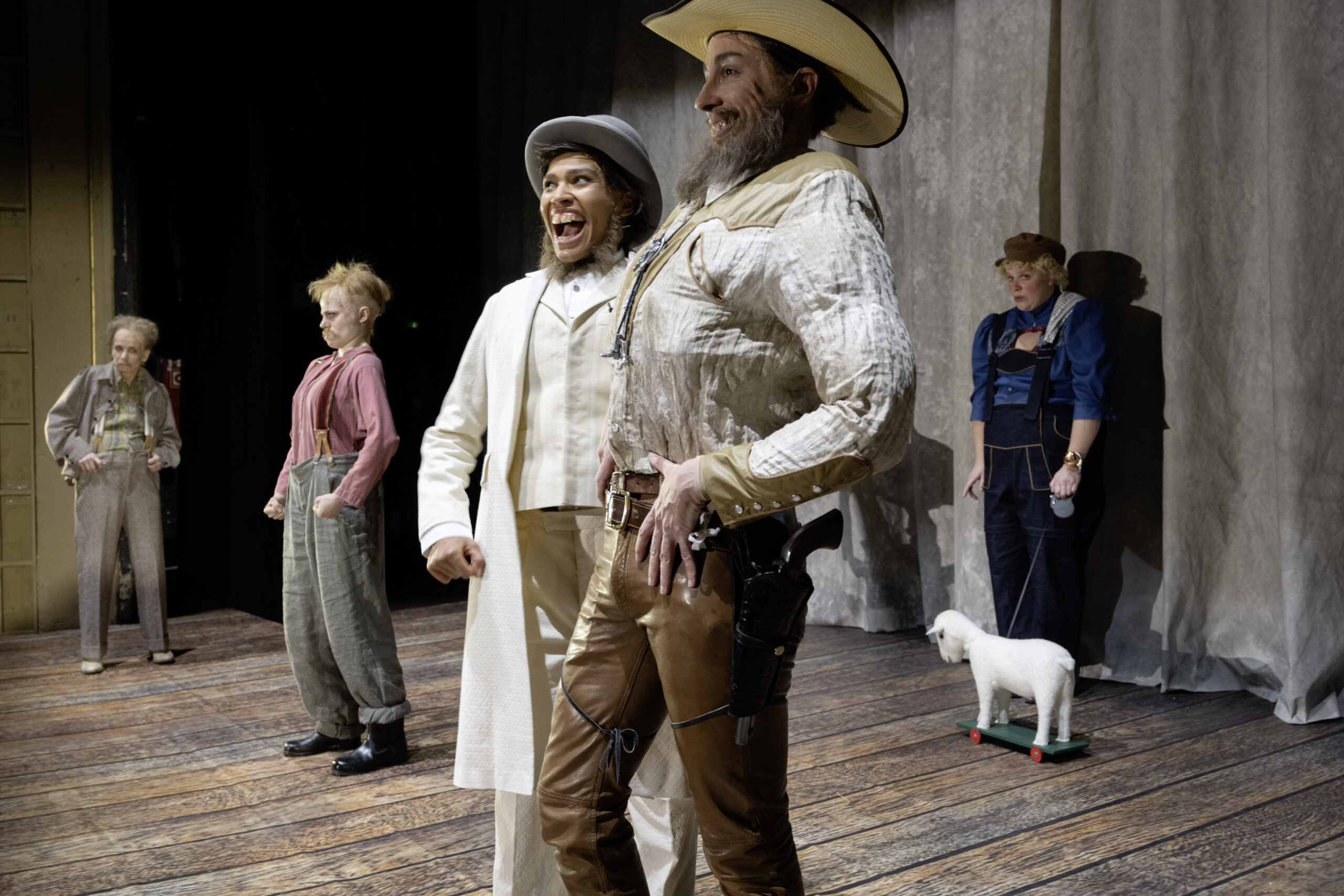 Szene aus dem Stück, als schräge Cowboys verkleidete Menschen auf der Bühne