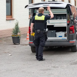 Polizisten stehen neben einem Fahrzeug