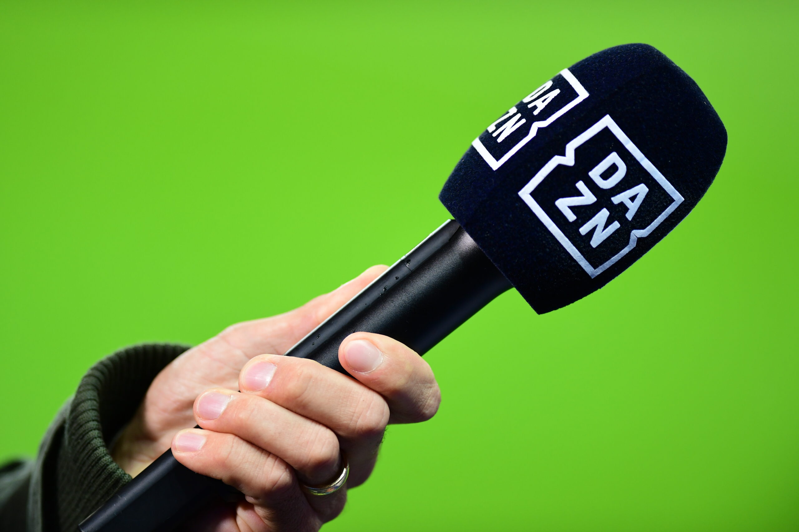 Ein Mikrofon der Streamingplattform DAZN wird von einer Hand gehalten