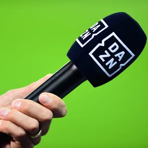 Ein Mikrofon der Streamingplattform DAZN wird von einer Hand gehalten