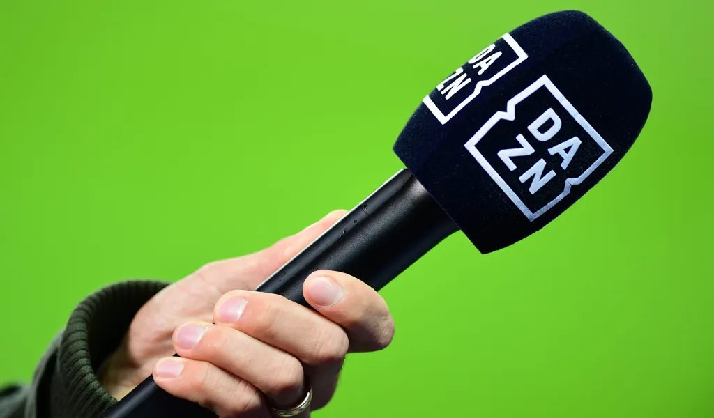 Ein Mikrofon der Streamingplattform DAZN wird von einer Hand gehalten