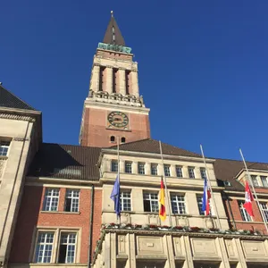 Die Fahnen vor dem Kieler Rathaus hängen auf Halbmast.