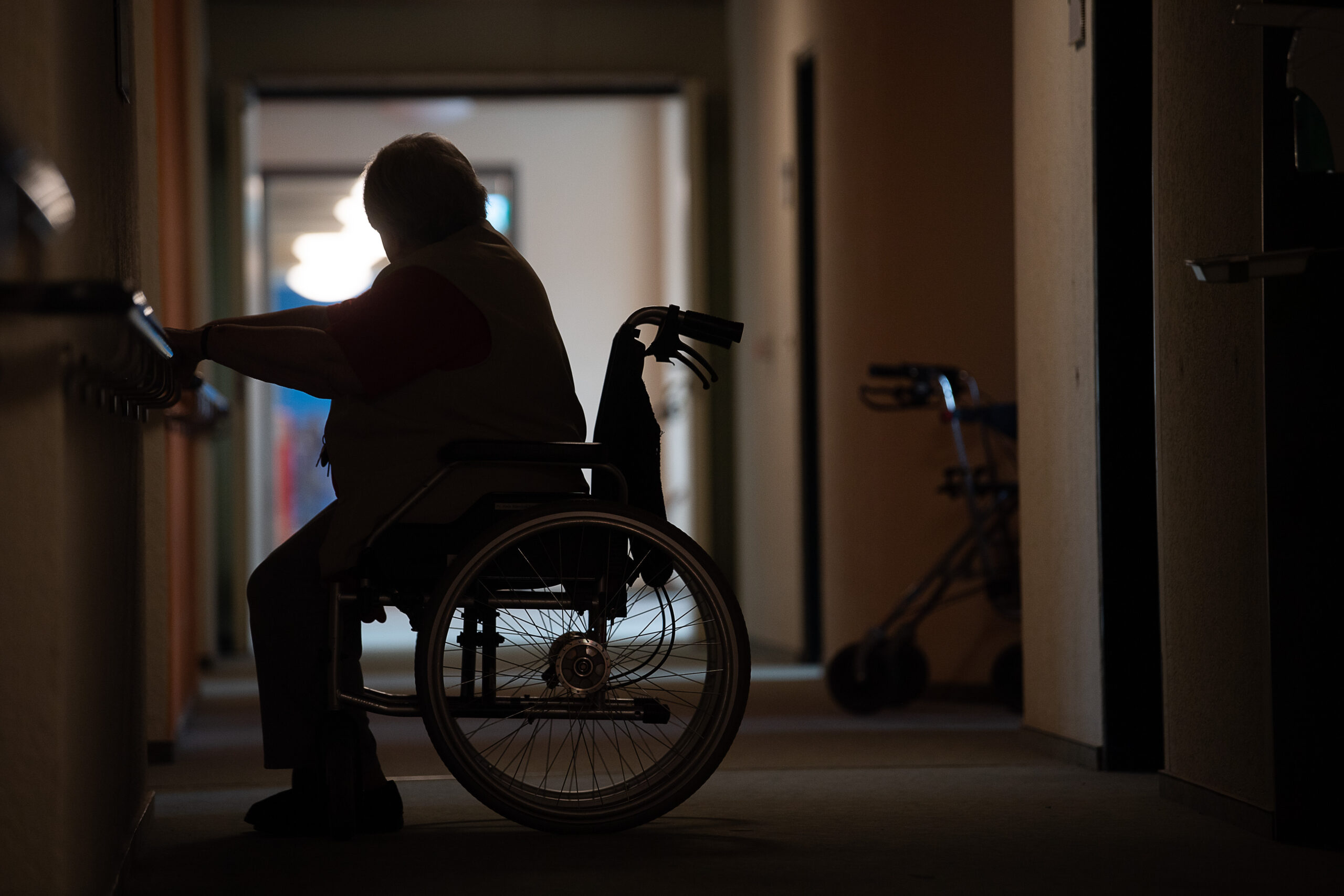 Schattenriss einer alten Dame im Rollstuhl.