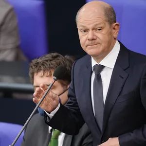 Bundeskanzler Olaf Scholz steht im Bundestag an einem Mikrofon