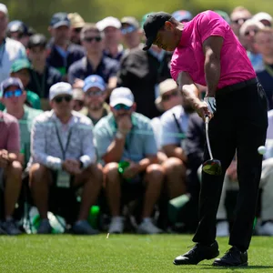 Tiger Woods in der Schlagbewegung mit Fans im Hintergrund