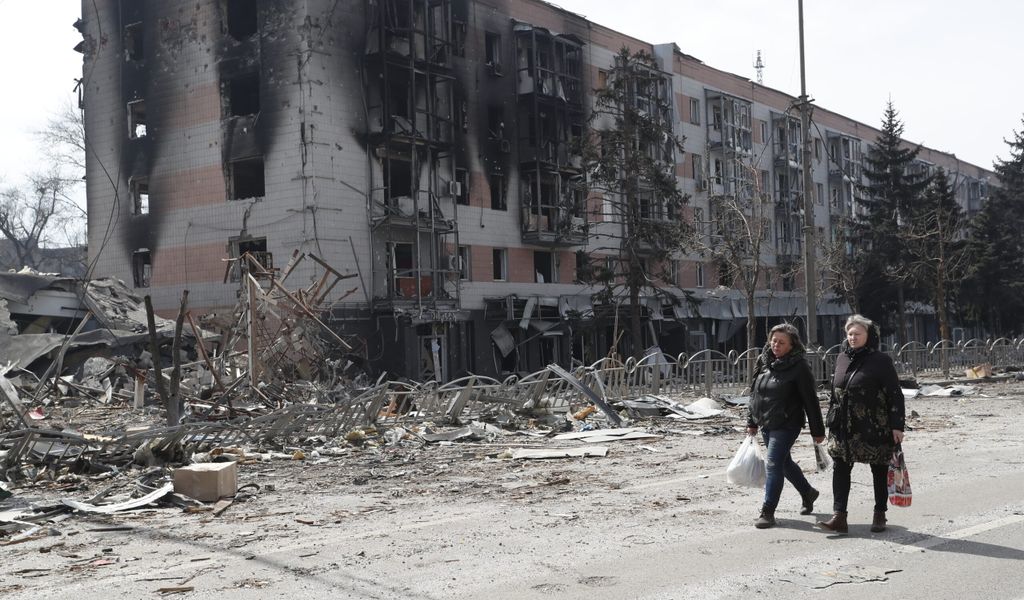 Bewohner von Mariupol laufen an zerstörten Gebäuden vorbei – in der Nacht soll es erneut Luftangriffe gegeben haben.