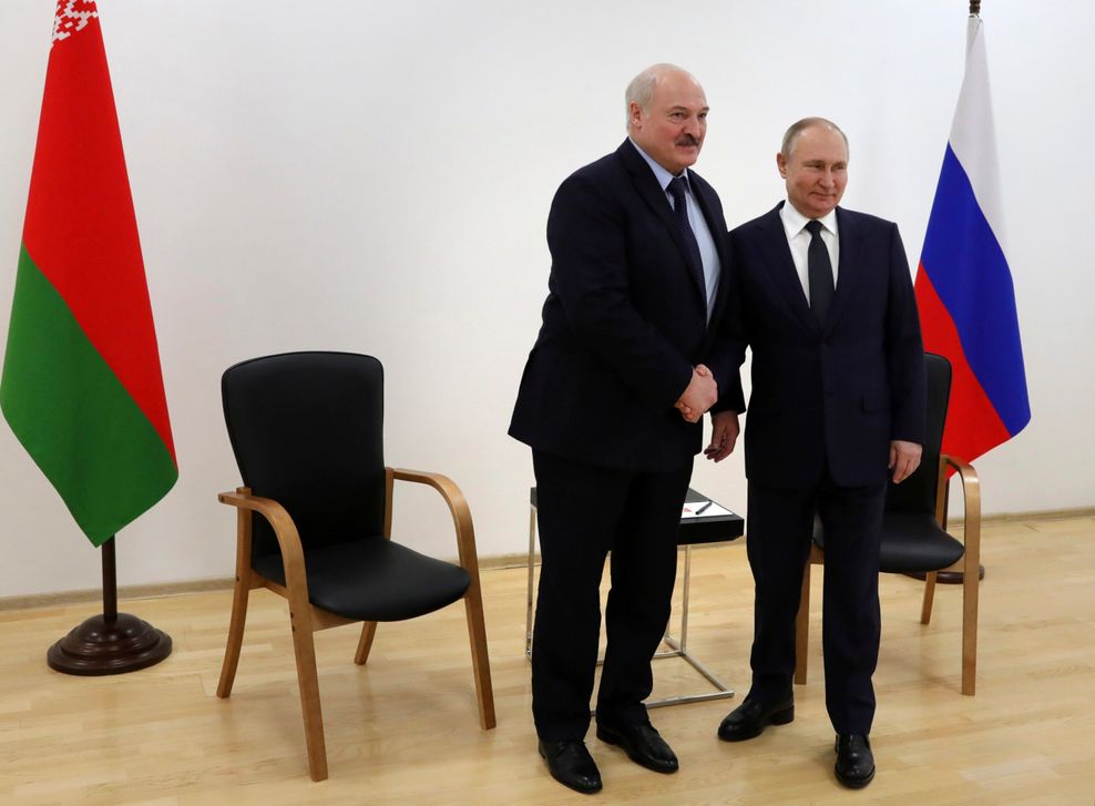 Alexander Lukaschenko schüttelt Wladimir Putin die Hand, beide lächeln in die Kameras