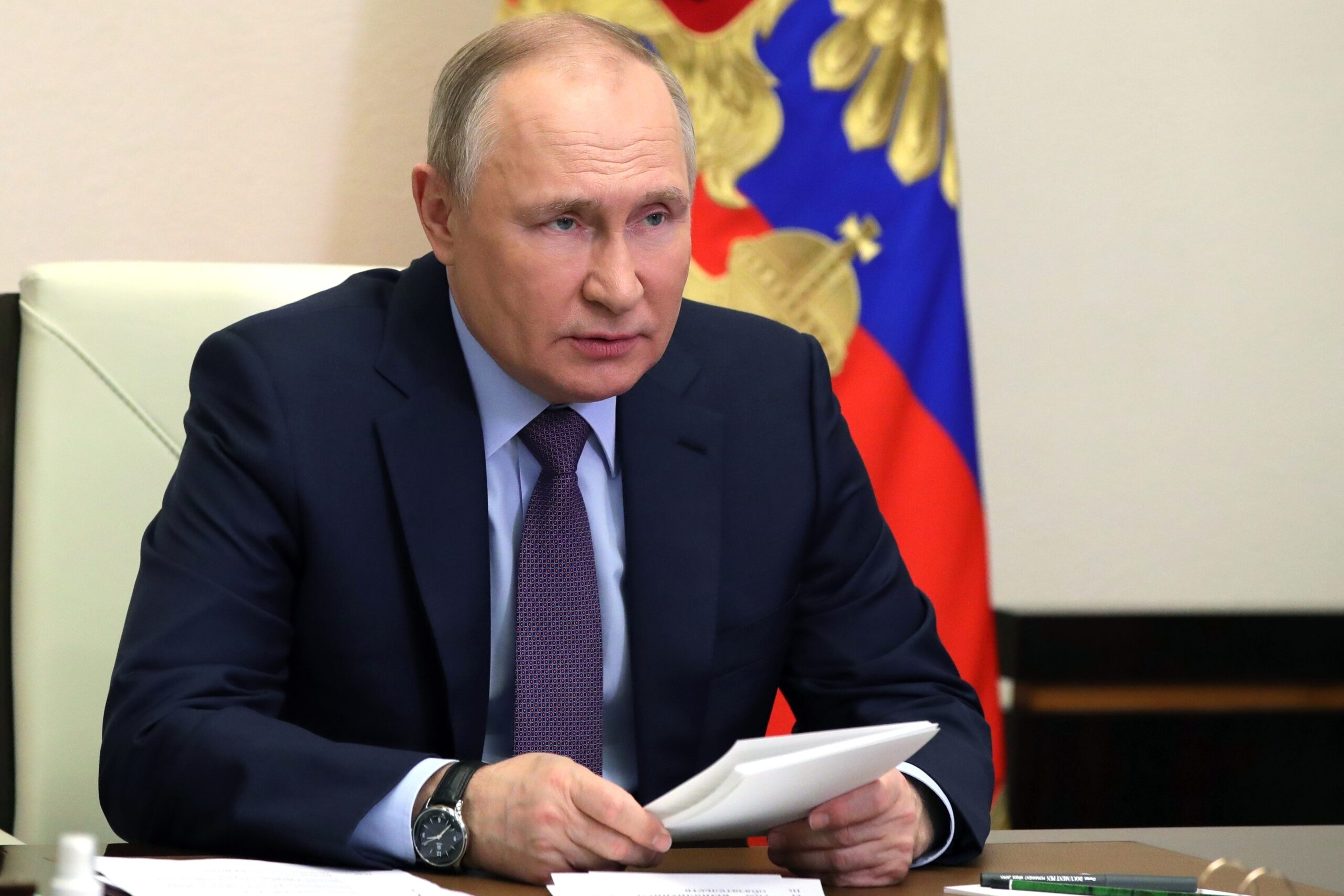 Wladimir Putin sitzt an seinem Schreibtisch und nimmt an einer Videokonferenz teil.