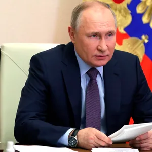 Wladimir Putin sitzt an seinem Schreibtisch und nimmt an einer Videokonferenz teil.