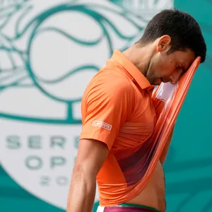 Novak Djokovic wischt sich das Gesicht mit seinem Trikot ab