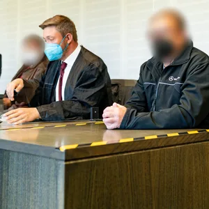 Die angeklagten Lkw-Fahrer mit ihrem Anwalt am Montag im Gericht.