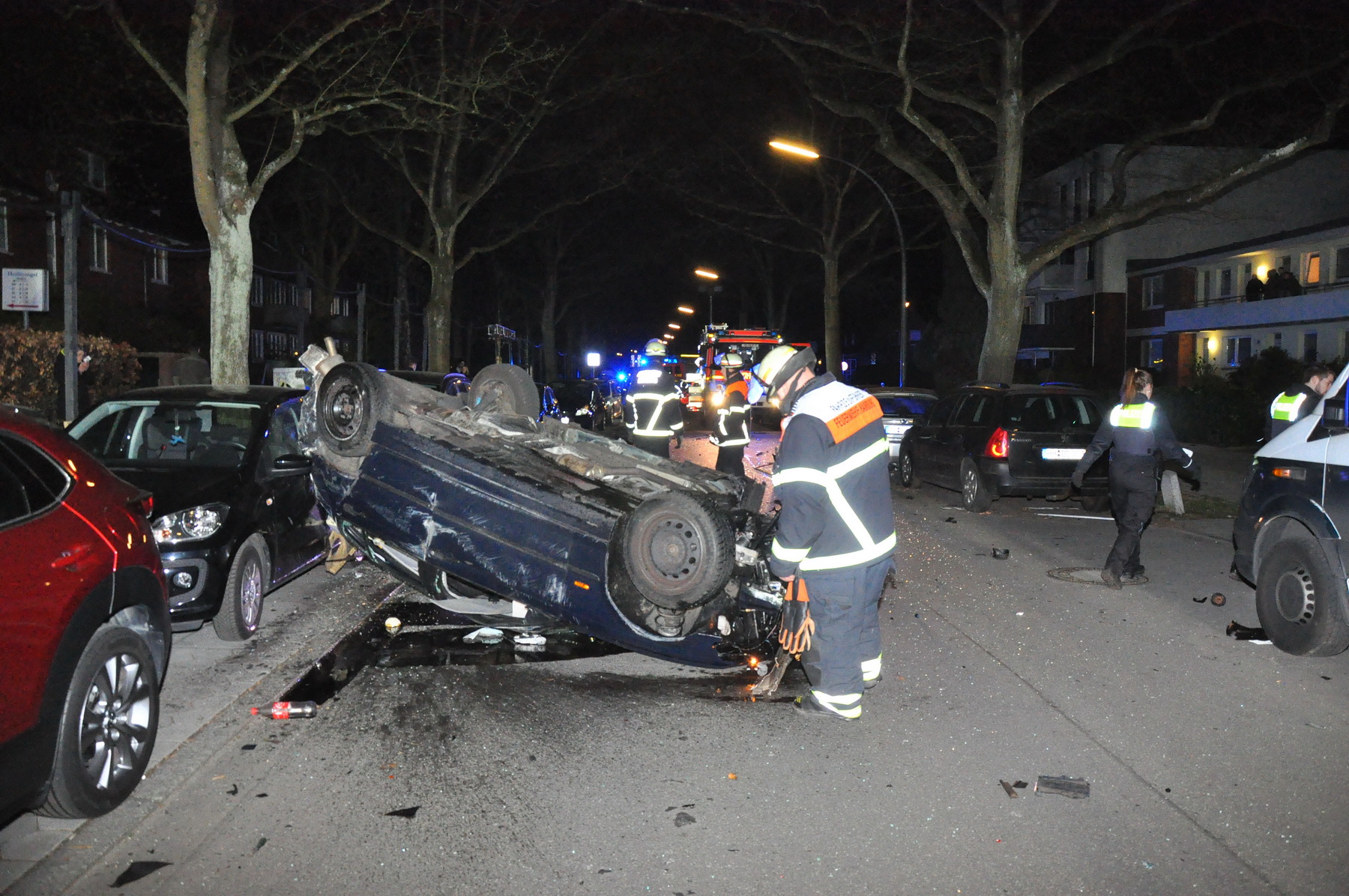Feuerwehrkräfte vor dem BMW. Das Auto hatte sich laut Angaben der Hamburger Polizei mehrfach überschlagen.